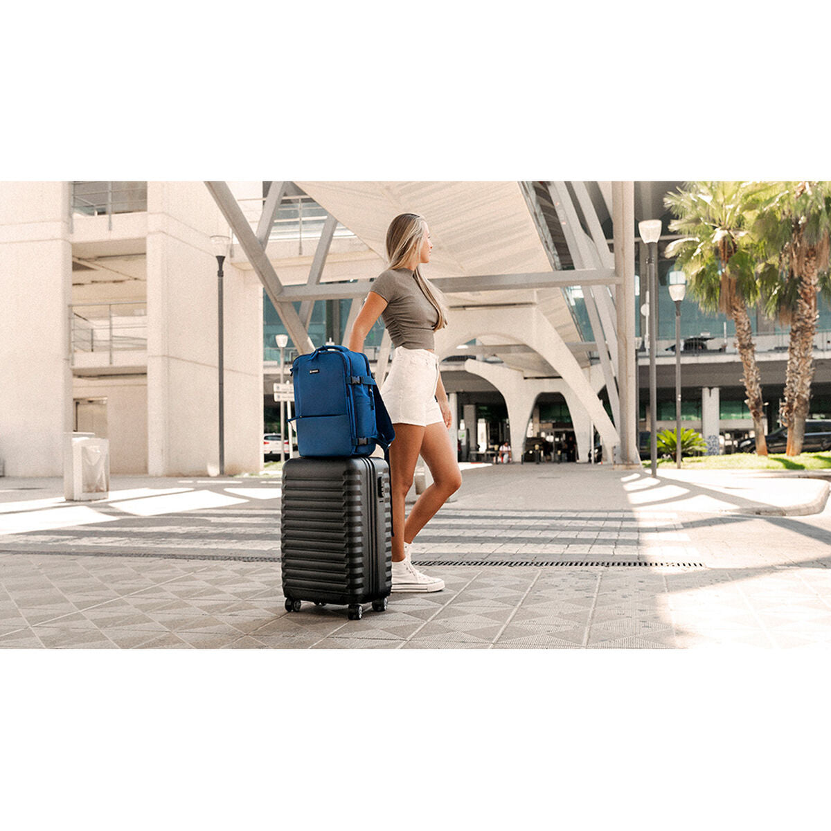 Numada b40 sininen reppu naisen vieressä matkalaukun päällä