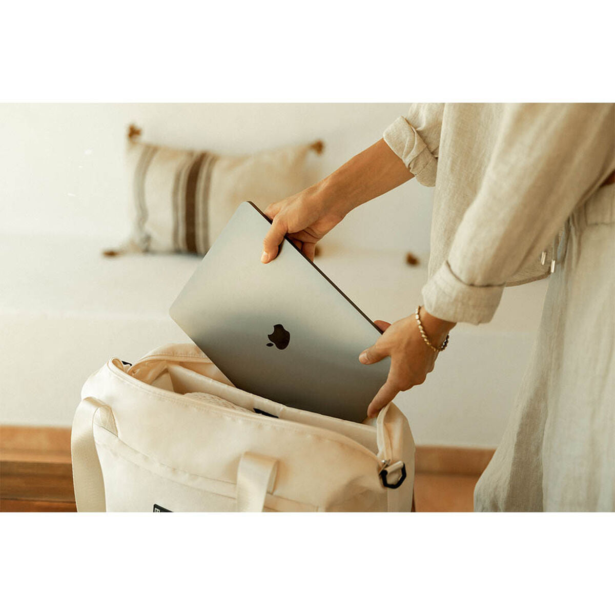 Numada urheilukassi beige vesitiivis nainen laittaa tietokonetta kassiin